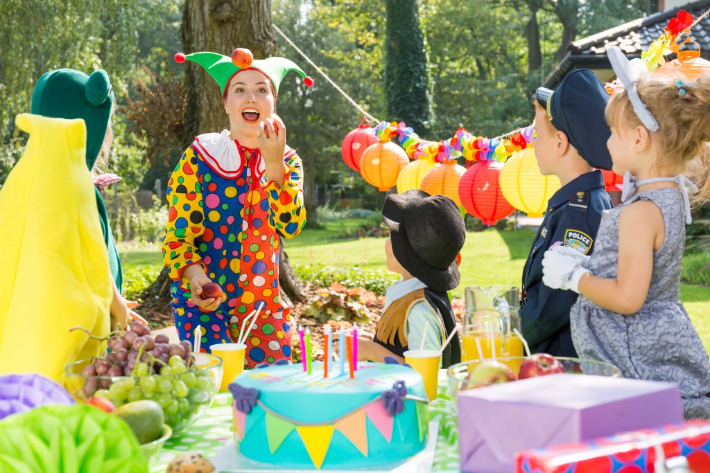 Children having fun at a party with a party entertainer wearing a funny costume.